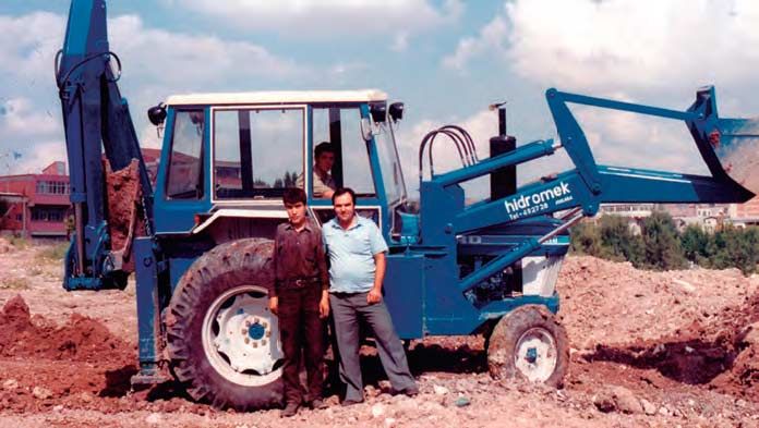 Hasán Bozkurt con dos de sus empleados y un tractor Ford equipado con pala y retro, al comienzo de la aventura industrial de Hidromek